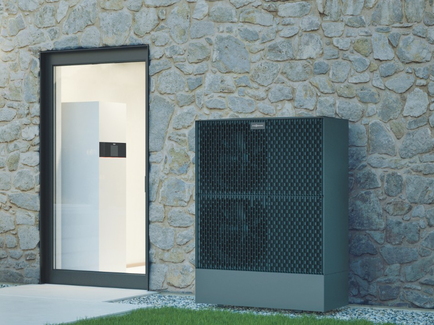 Die Wärmepumpe von Viessmann für Einfamilienhäuser. Im Vordergrund steht die Außeneinheit der Wärmepumpe, im Hintergrund die Inneneinheit.