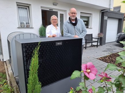 Zufriedener Besitzer einer neuen Wärmepumpe aus Eppingen vor ihrem Wärmepumpen-Außengerät stehend.