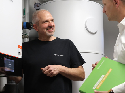 Ein Erdgas Südwest Heizungsbauer und Kundenberater tauschen sich über den Heizungswechsel aus.