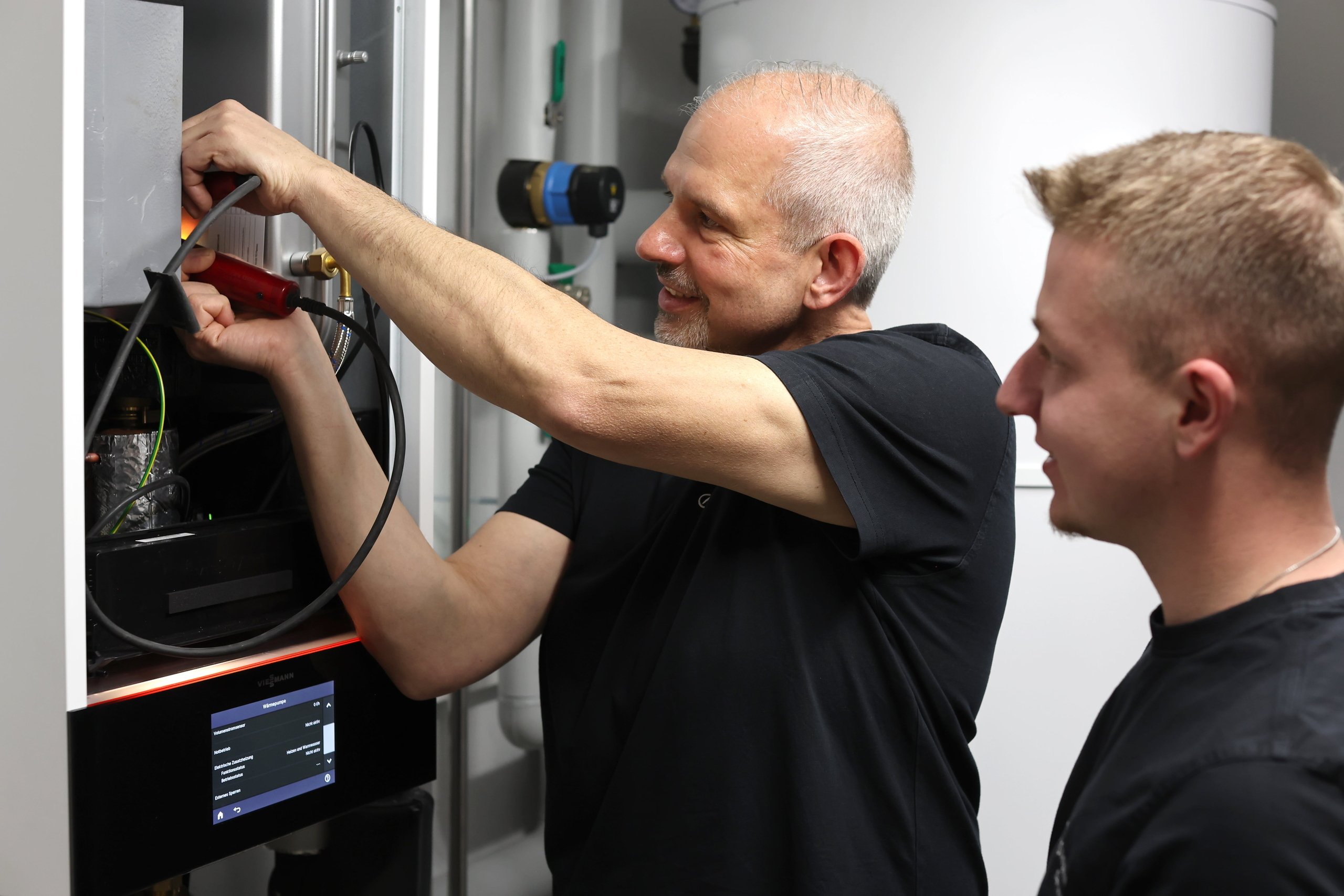 Zwei Heizungsinstallateure überprüfen den korrekten Betrieb der neuen Heizung.