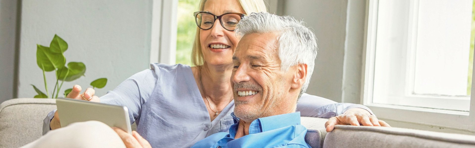Ehepaar empfiehlt auf einer Couch sitzend die Erdgas Südwest als Gas- und Stromanbieter, Heizungsanbieter sowie Photovoltaikanbieter an Freunde und Bekannte und erhält eine Prämie dafür.