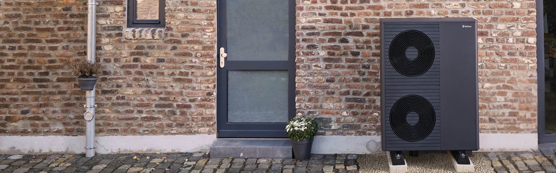 Außenaufnahme eines Gebäudes mit einer Außeneinheit einer Vaillant Wärmepumpe