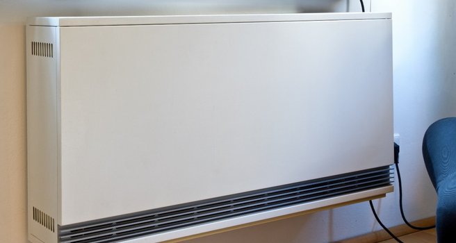 Das Innenmodul einer Nachtspeicherheizung unter einer Fensterbank im Wohnzimmer eines Einfamilienhauses.