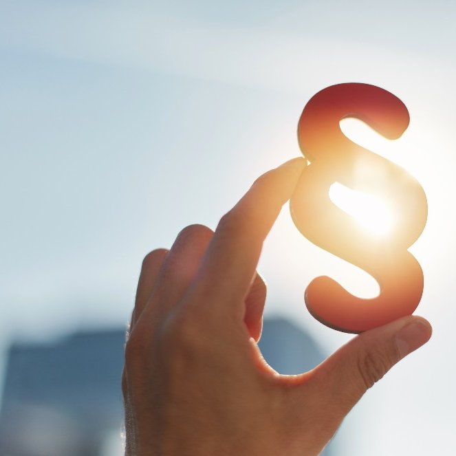 Zeichen Paragraph gegen Sonne gehalten