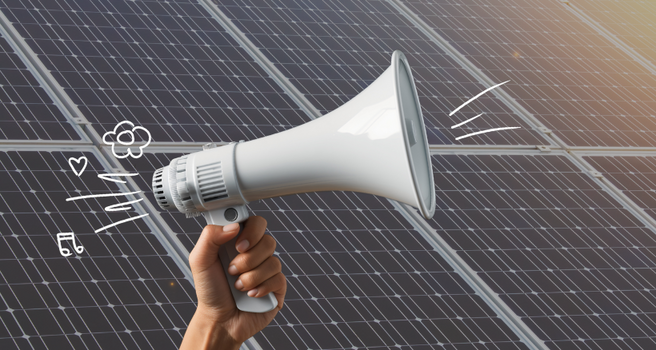 Mit einem Megaphon wird zur Solaraktion gerufen. Photovoltaikmodule im Hintergrund.