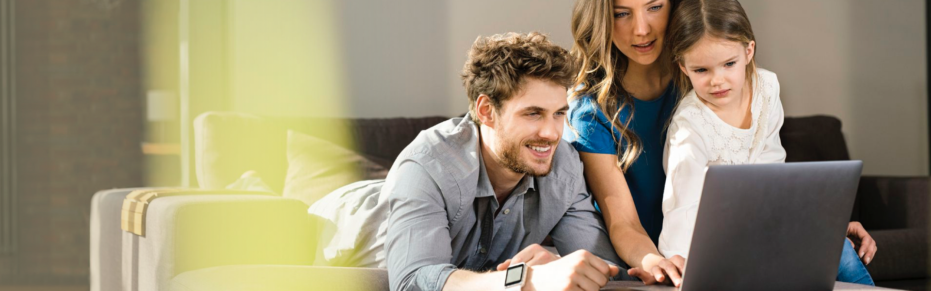 Eltern mit ihrem Kind vor einem Laptop