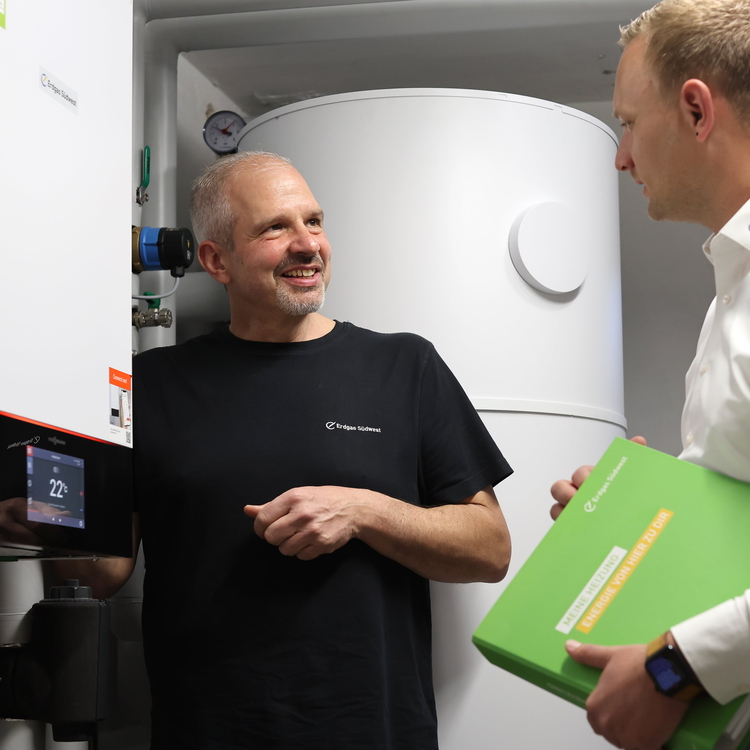 Ein Erdgas Südwest Heizungsbauer und Kundenberater tauschen sich über den Heizungswechsel aus.