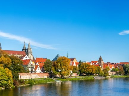 Stadtbild von Ulm mit Blick über die Donau auf das Ulmer Münster und die historische Altstadt bei sonnigem Wetter.