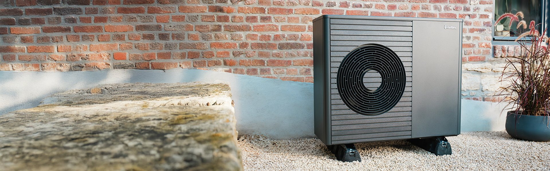 Luft-Wasser-Wärmepumpe aroTHERM plus von Vaillant vor einer Hauswand installiert.