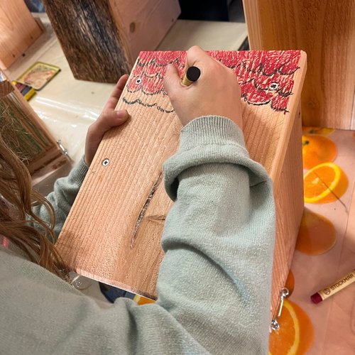 Kinder mit Mitarbeitern der Erdgas Südwest beim Basteln eines Nistkastens im Rahmen der Erdgas Südwest Nachhaltigkeitswochen.