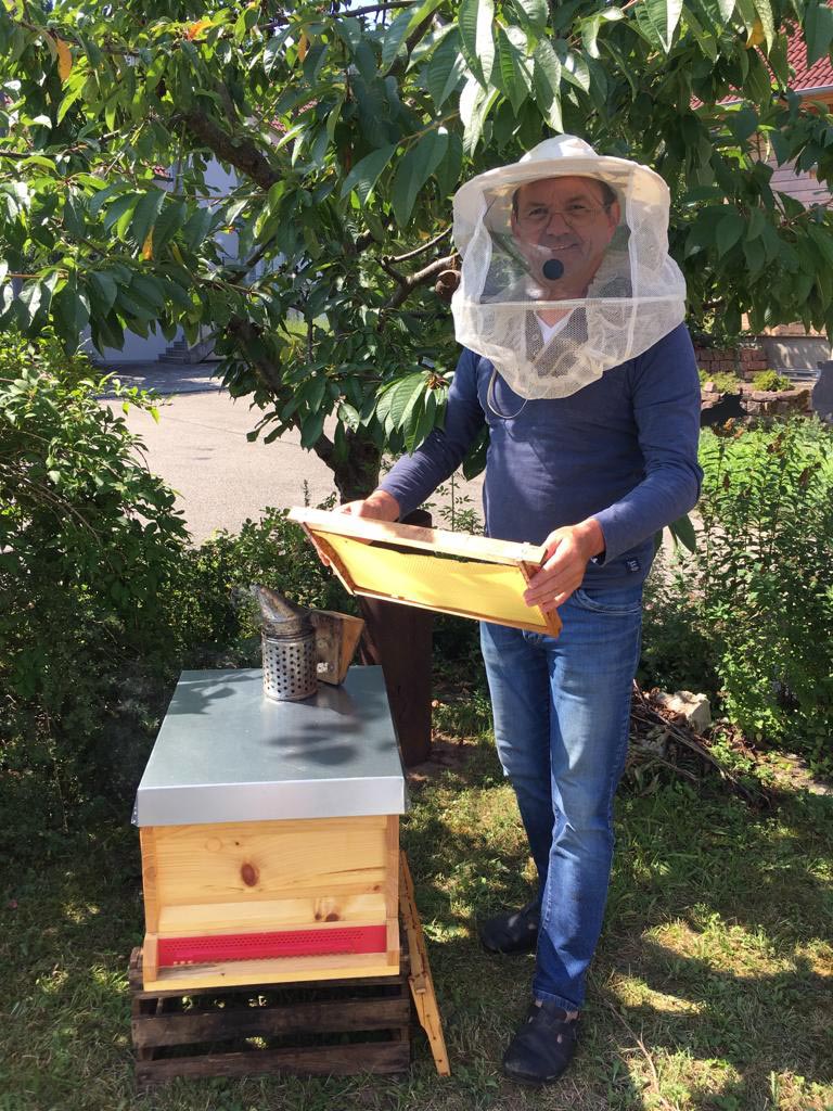 Imker der Erdgas Südwest vor Bienenstock