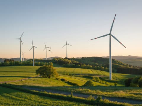 Mehrere Windkraftanlagen in hügeliger Landschaft