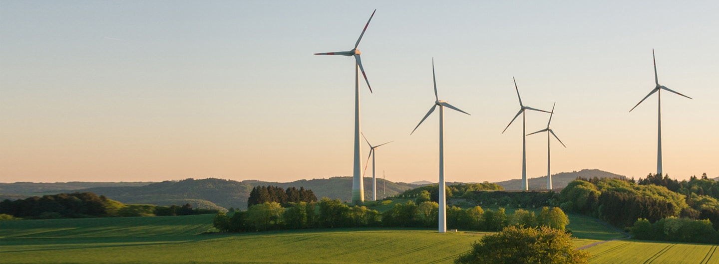 Mehrere Windkraftanlagen in hügeliger Landschaft