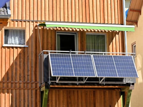 Balkonkraftwerk an einem Wohnhaus mit Holzfassade