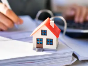 Ein Energieberater arbeitet an Papierunterlagen, auf denen ein kleines Haus steht