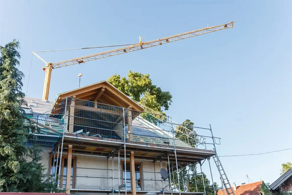 Ein Haus mit Gerüst und Kran im Hintergrund